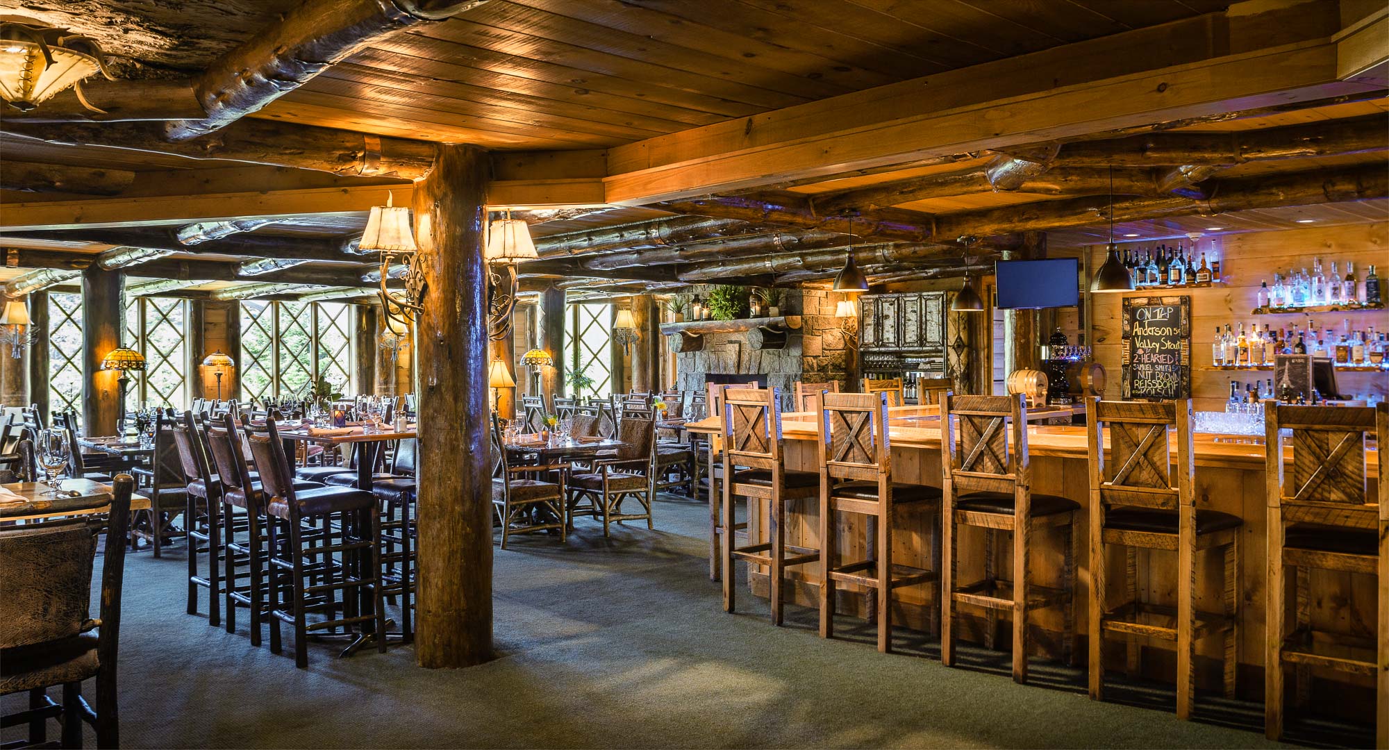 The cozy wood-lined bar of a luxury mountain resort.