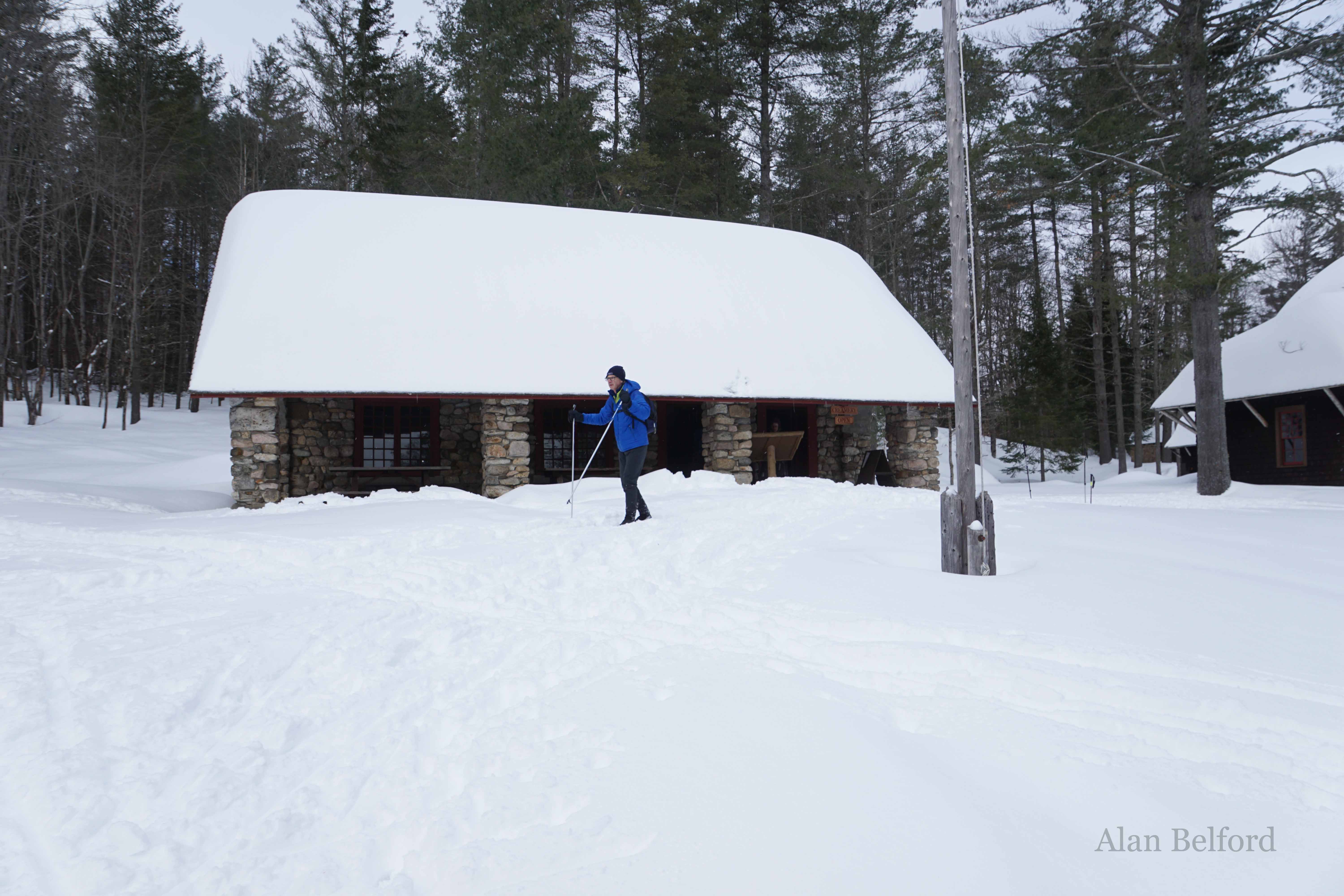 Another skier checks out the buildings of the farm complex.