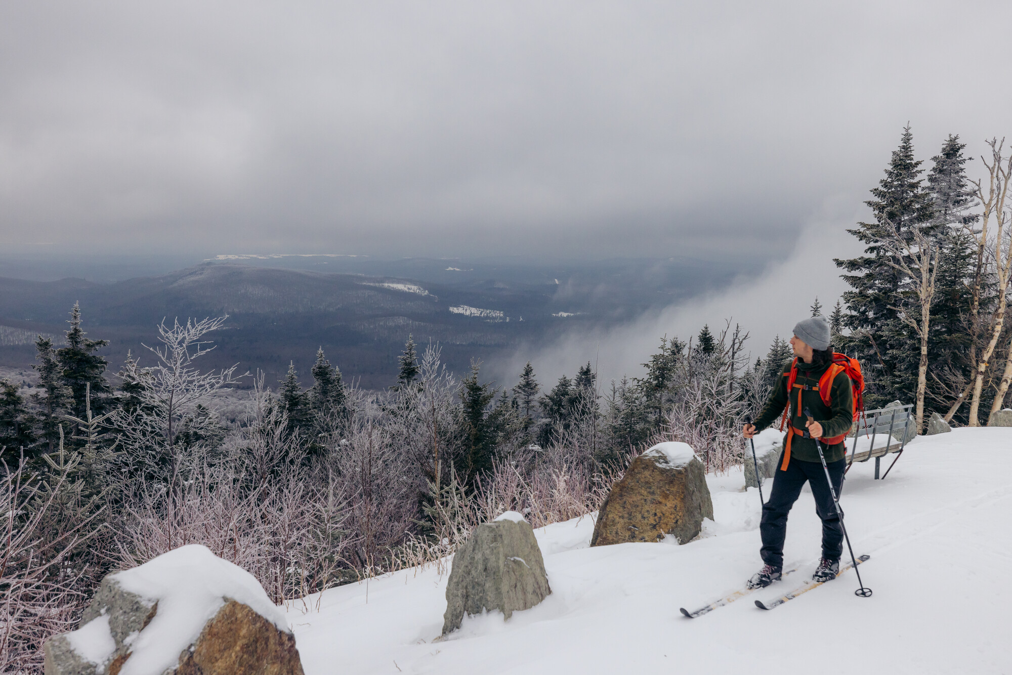 A cross country skier near the edge of a road in the mountains