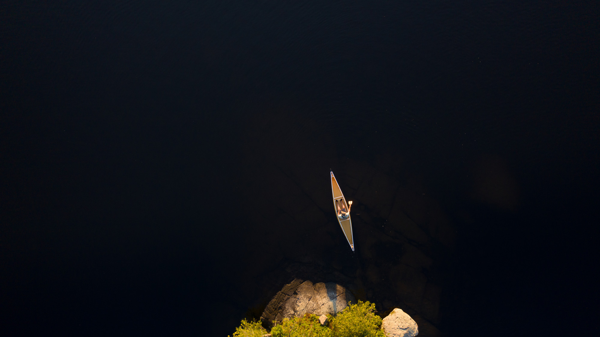View from directly above of a solo man in a canoe.
