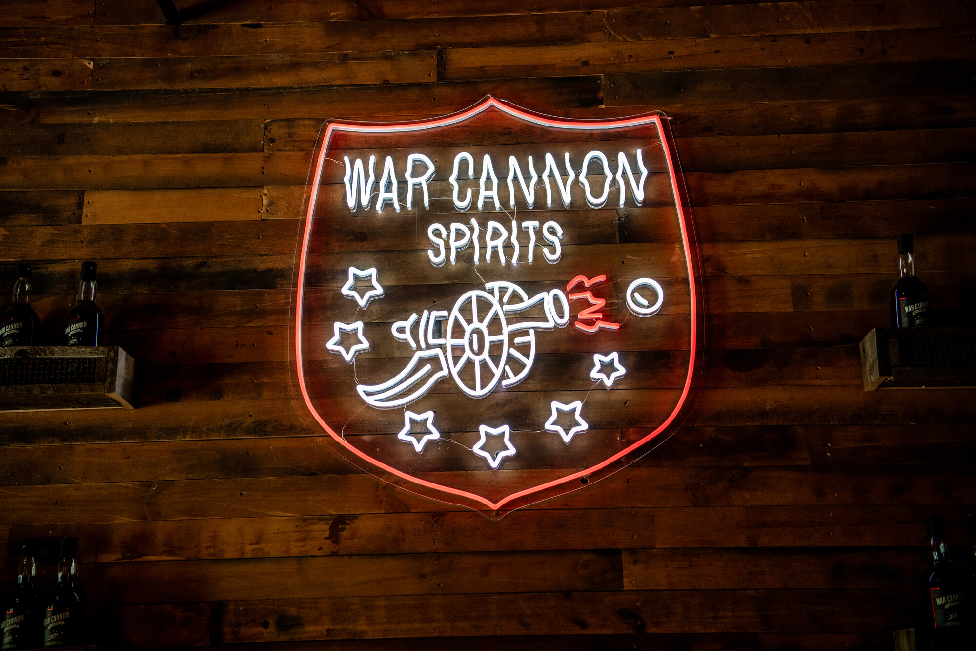 A lighted neon sign displays the War Cannon Spirits logo 