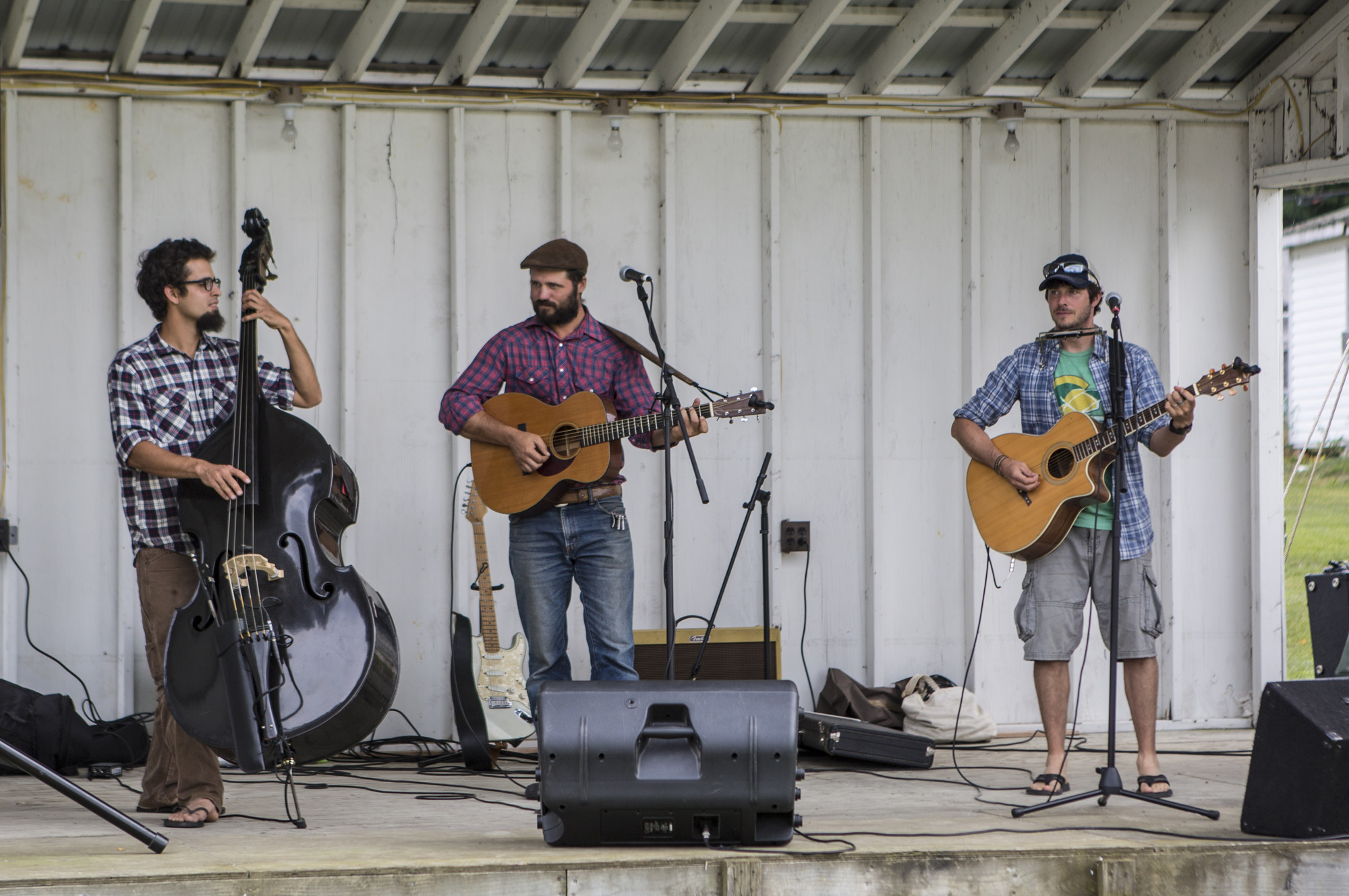 A string band trio performs on a stage.