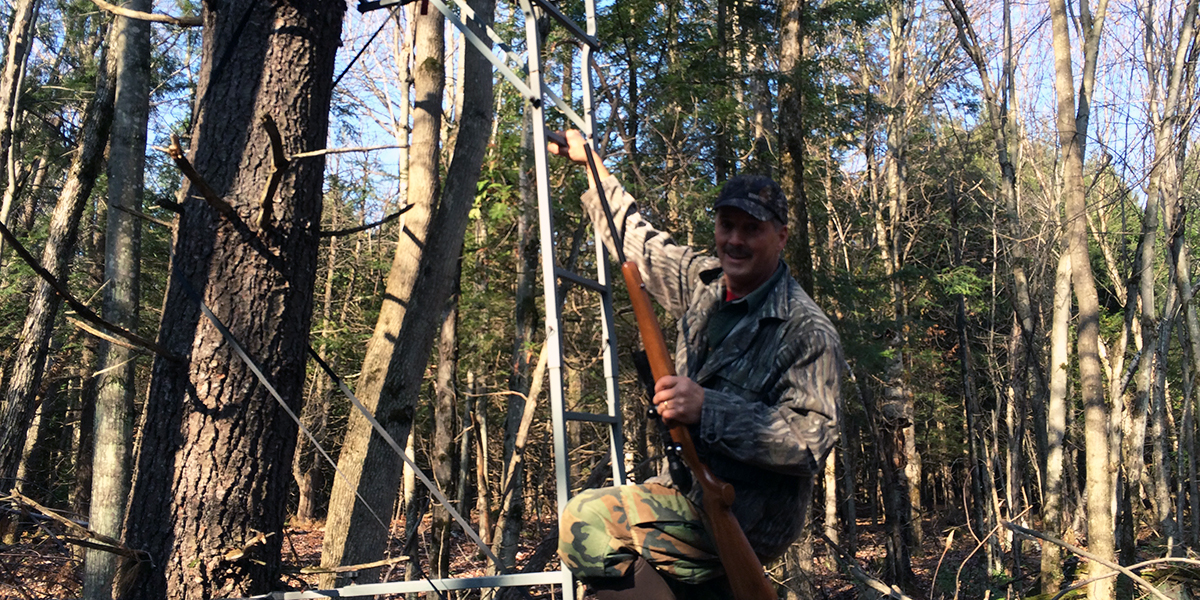 Climbing a tree stand, Adirondacks, USA