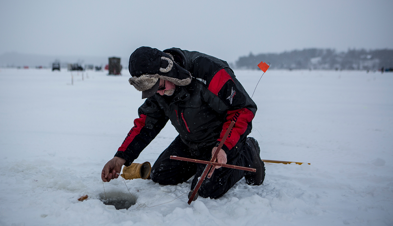 A man checks his tip-up on the ice