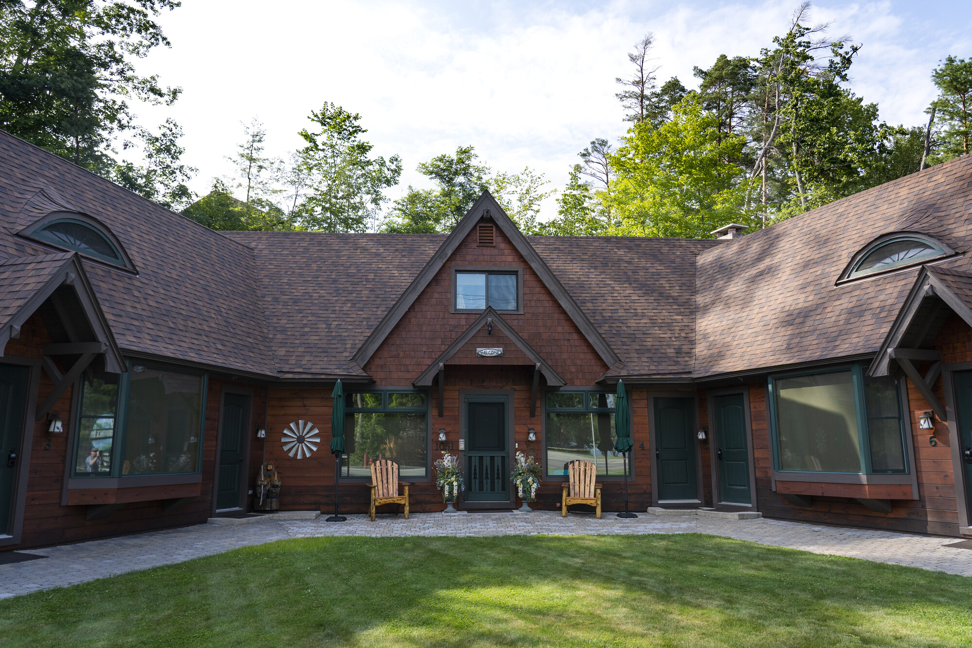A brown lodge with fresh trimmed yard in front. 