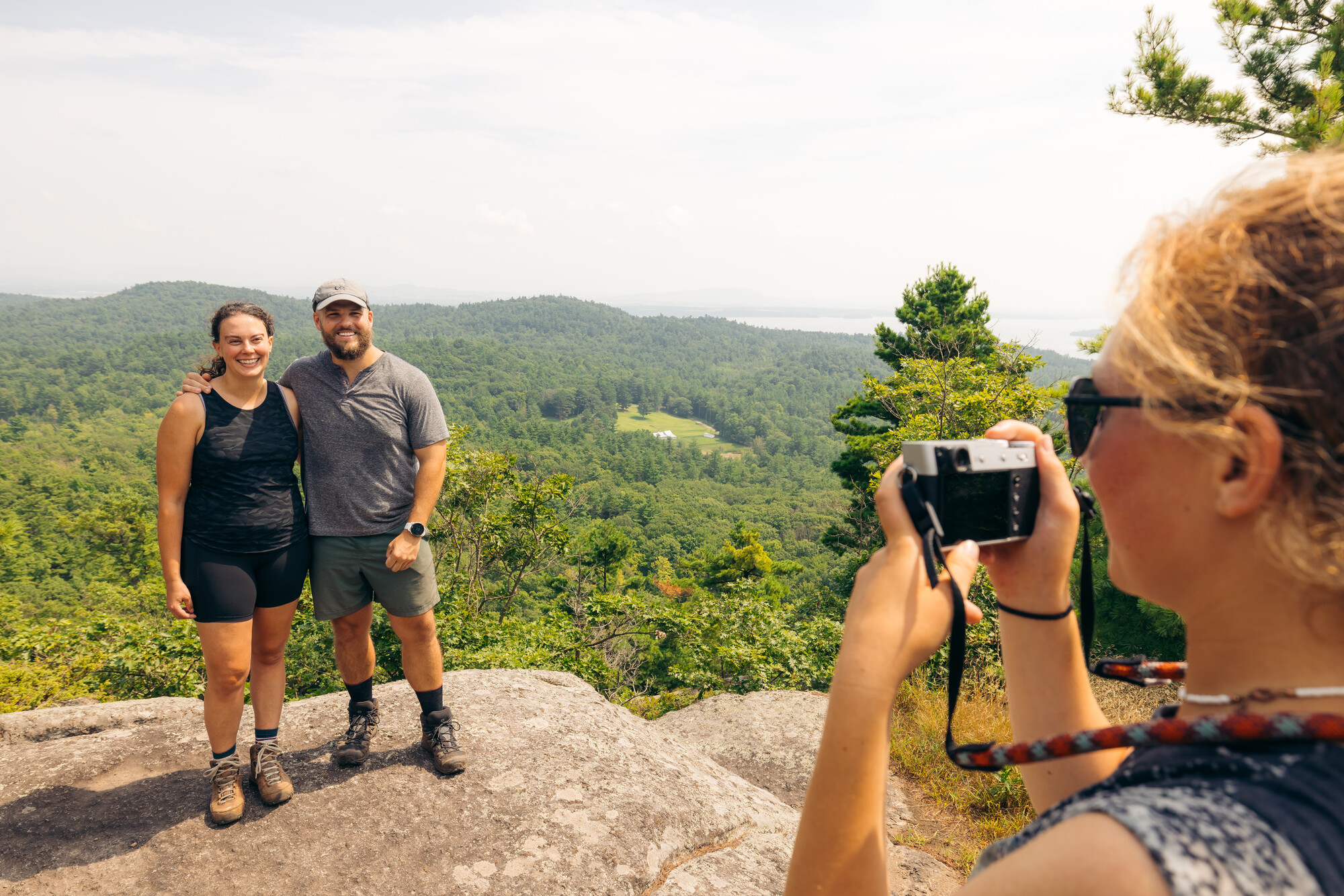 A couple getting their photo taken at the summit of Coon Mountain.