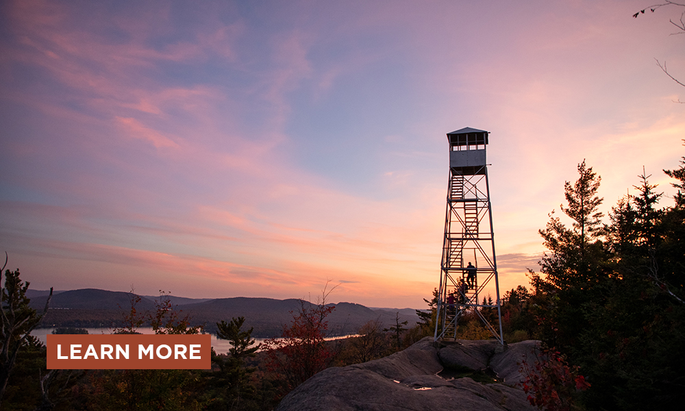 A beautiful sunset behind a historic fire tower.