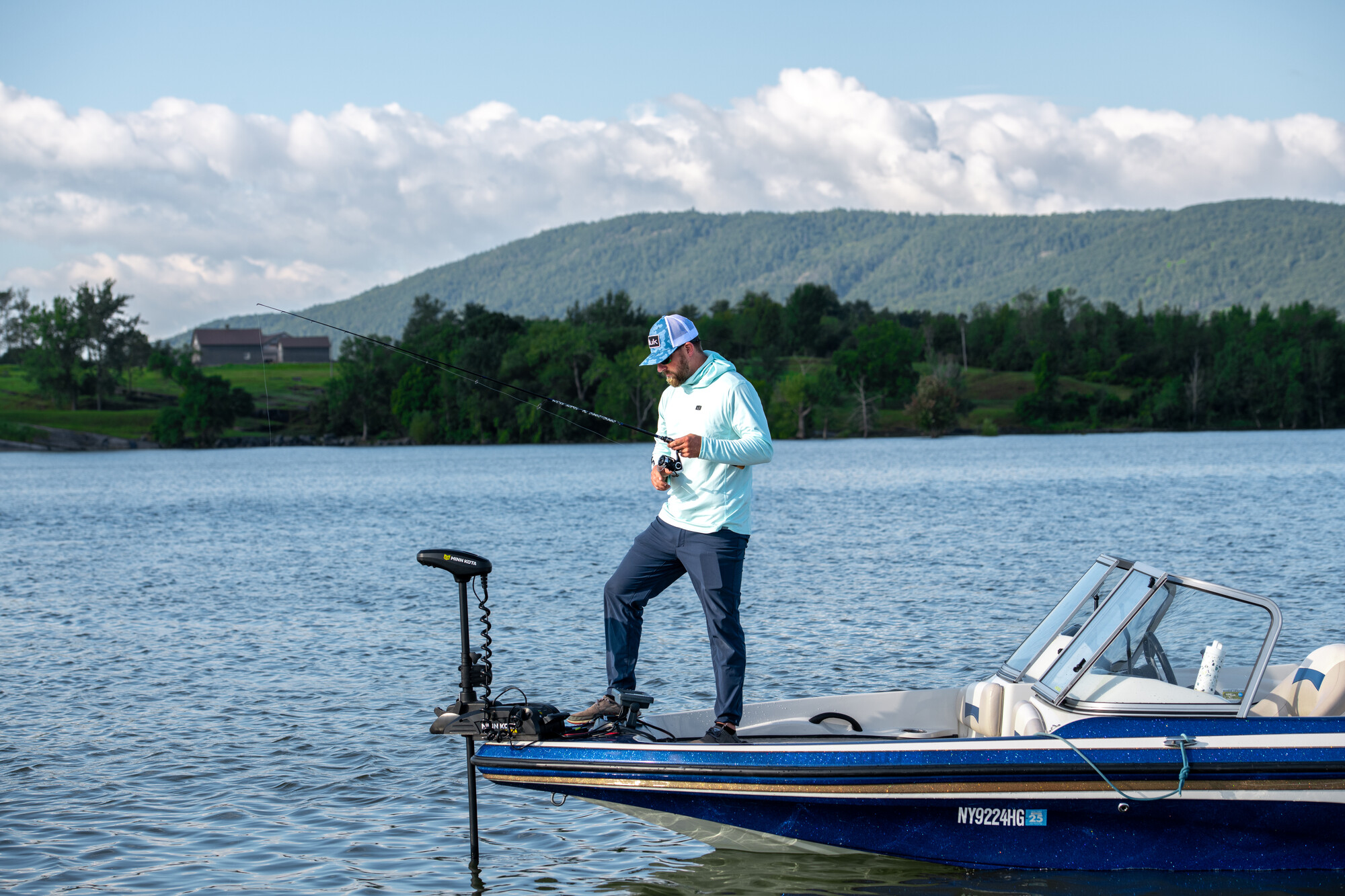 A man fishing off a motor boat on Lake Champlain.