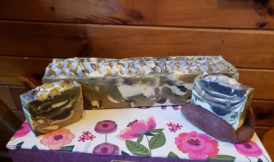 A large uncut bar of multi-color soap, and two small cut pieces.