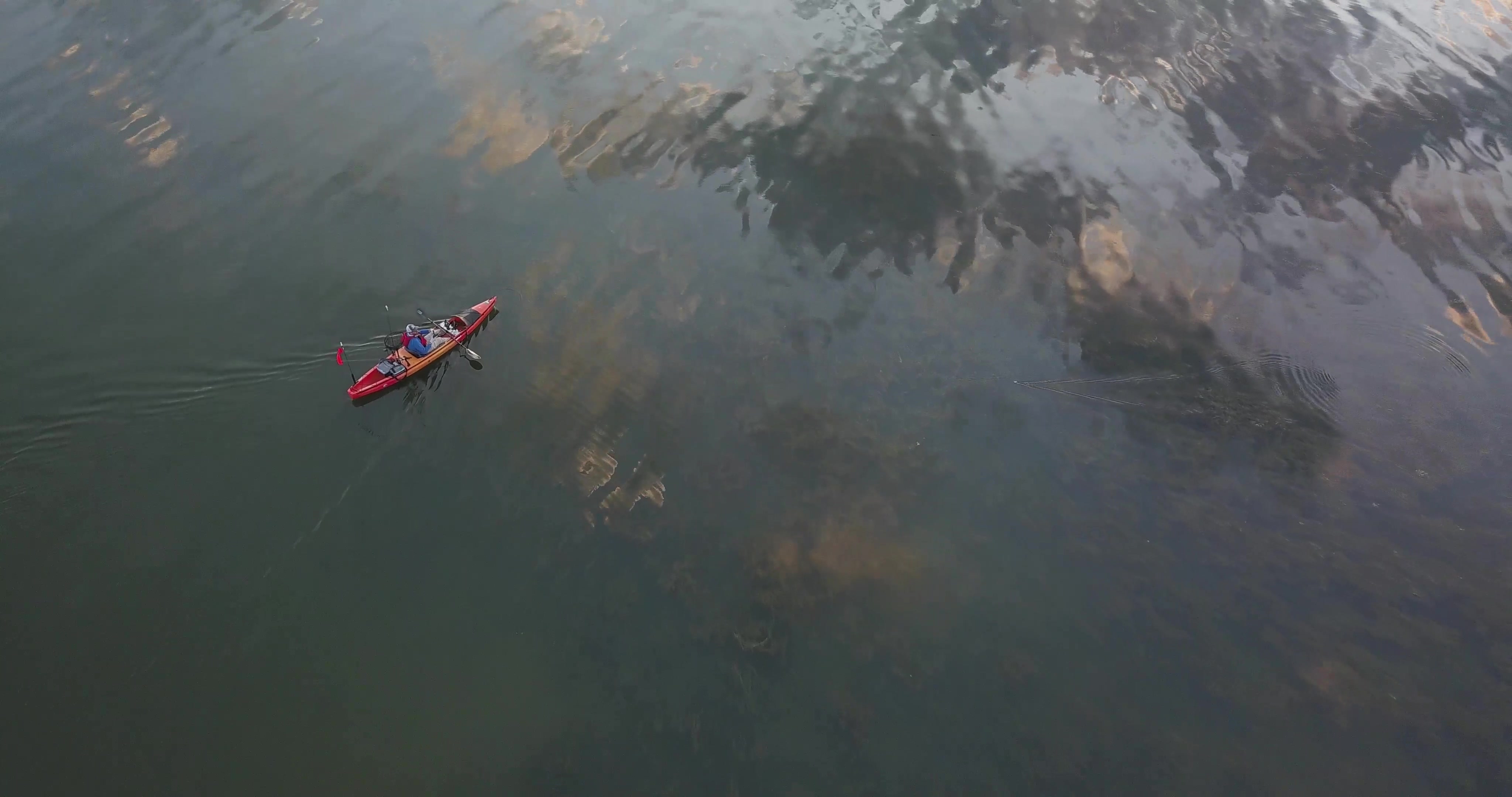 A birds eye view of the kayak fisher against the silhouette of Lake Champlain's water.