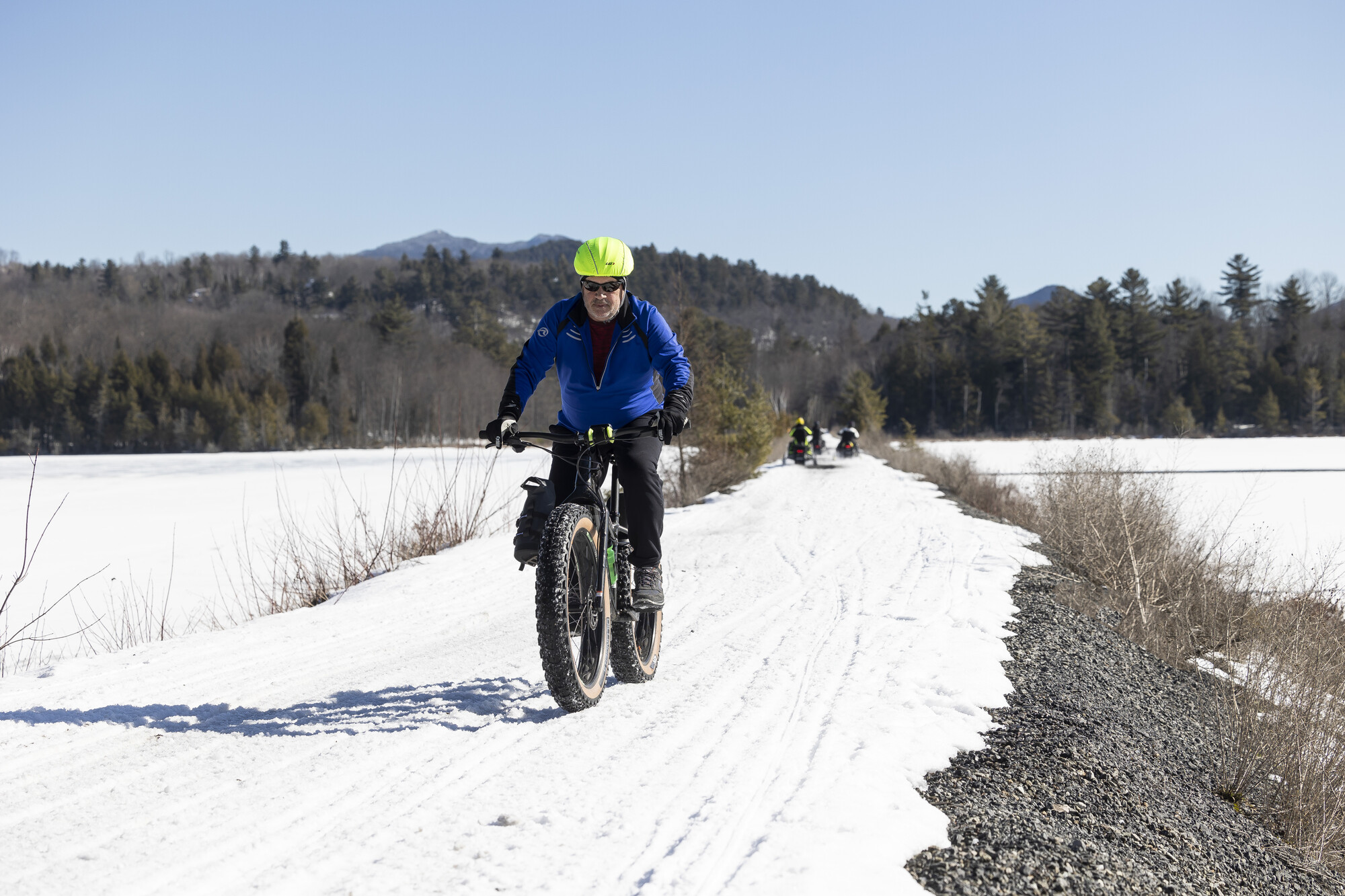 A fat-tire biker rides on a winter rail trail