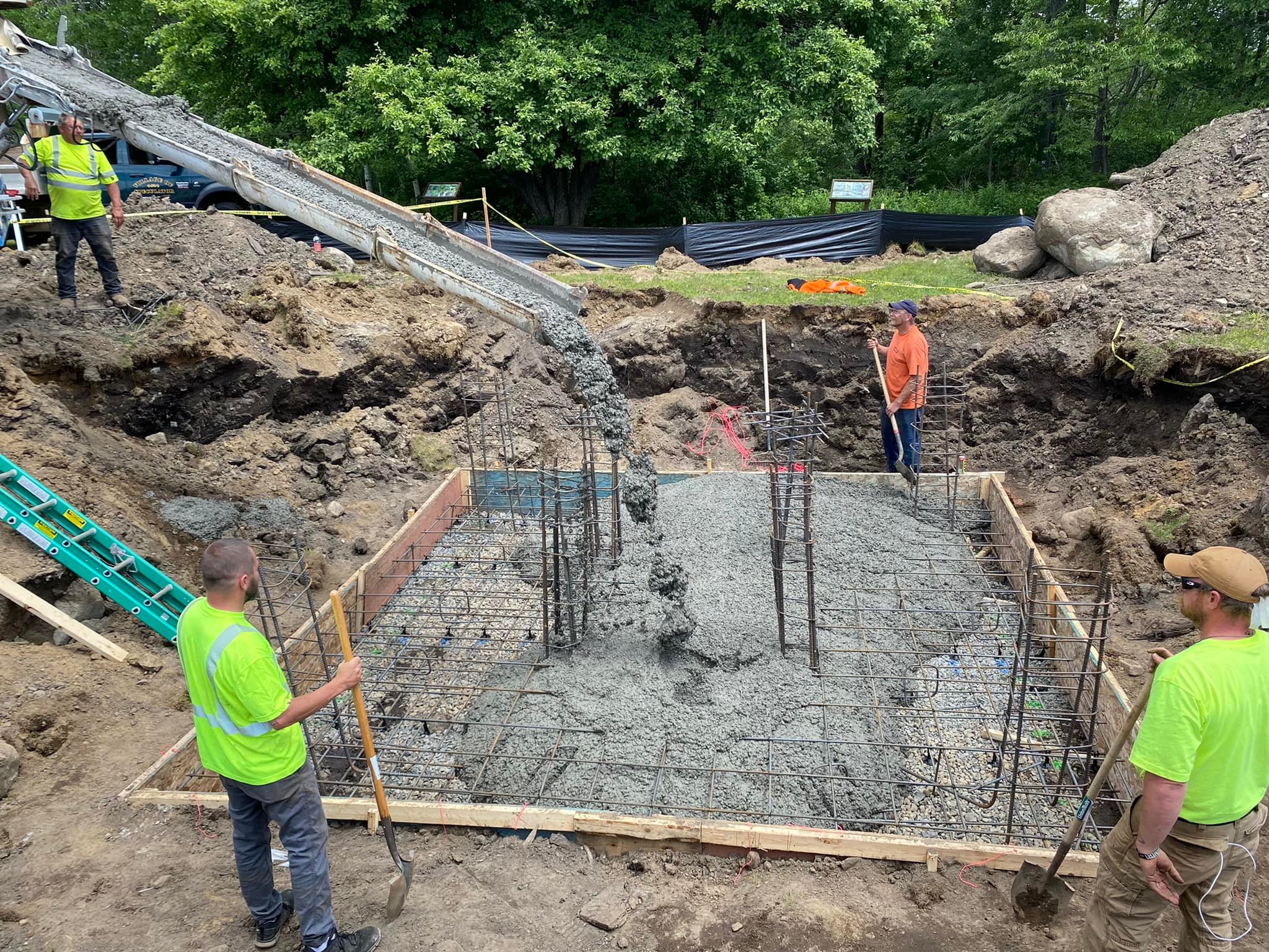 Men working on laying the foundation (concrete) for the new fire tower.