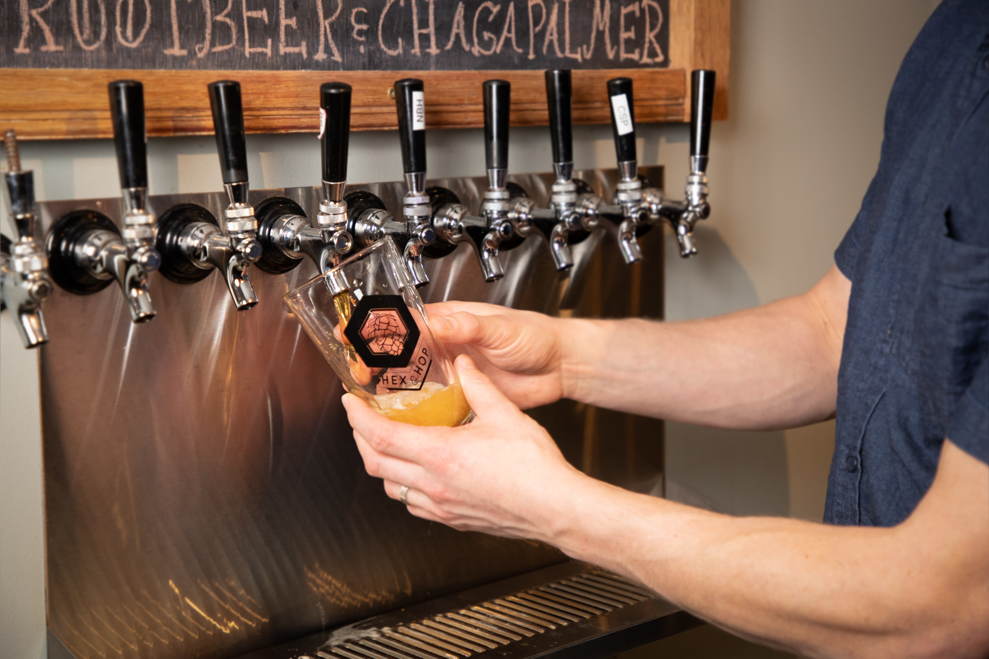 A pint glass being filled with draught beer