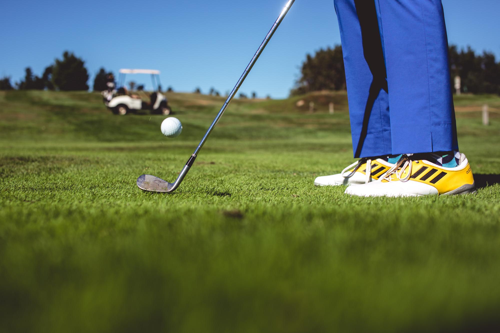 A golfer chipping a ball off the fairway