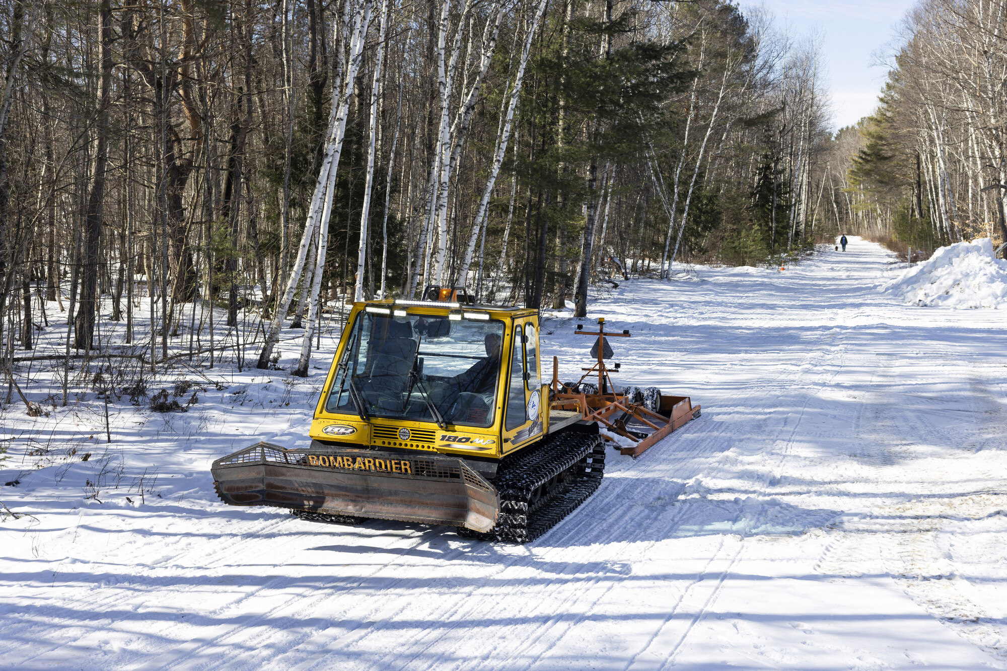 A snow groomer on a snowmobile trail