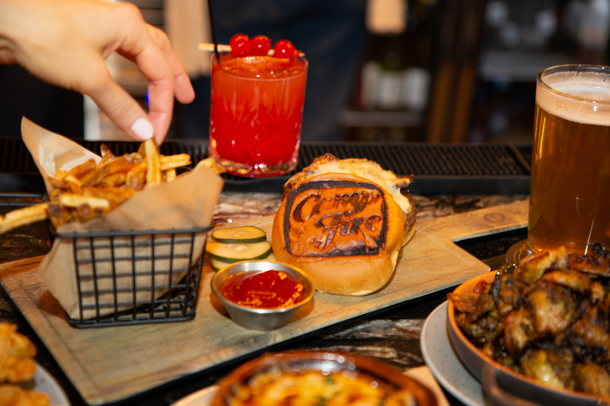 Campfire is always memorable Fries, a cocktail, a beer, and burger with a campfire branding on the bun.