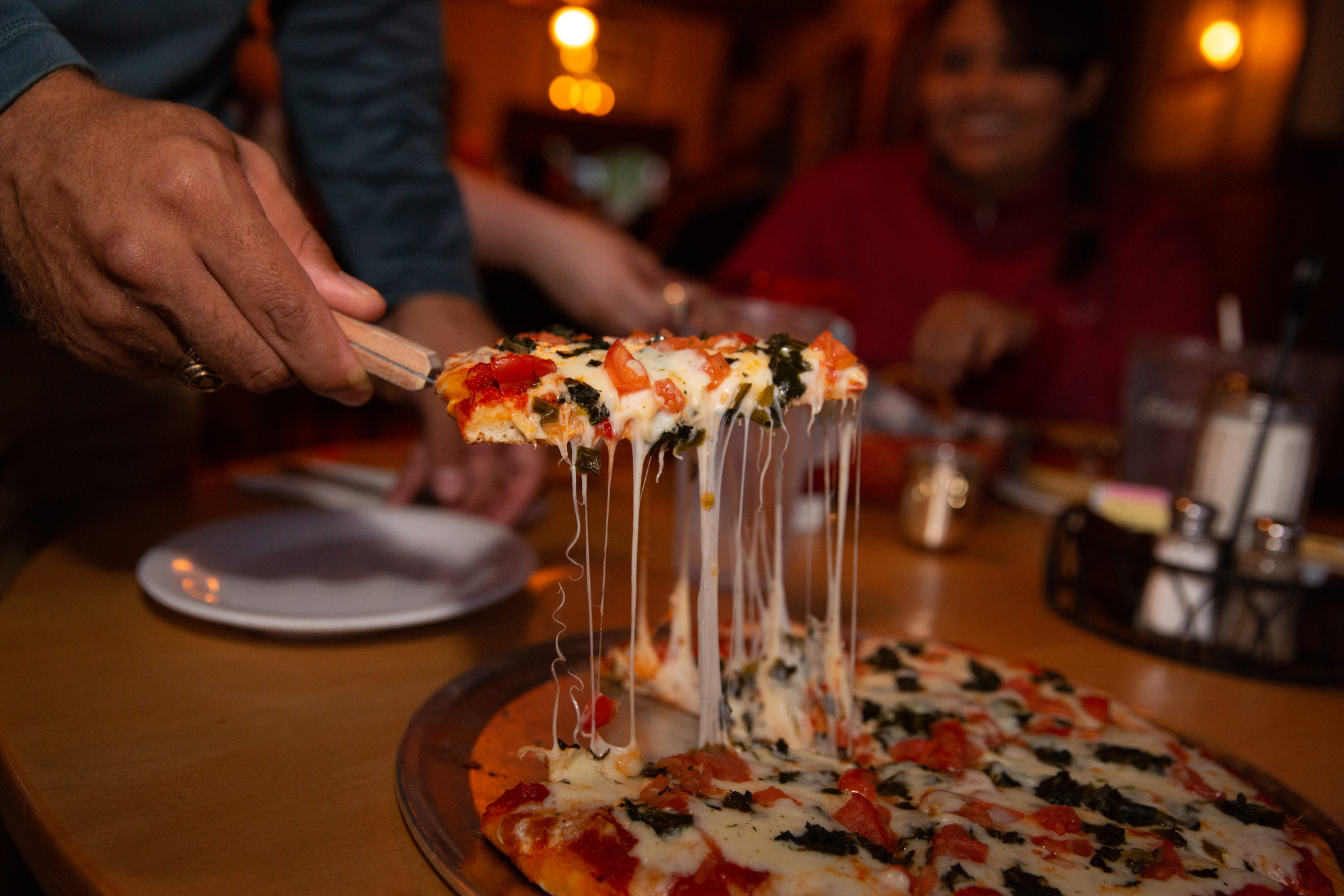 A slice of pizza being lifted from the pie