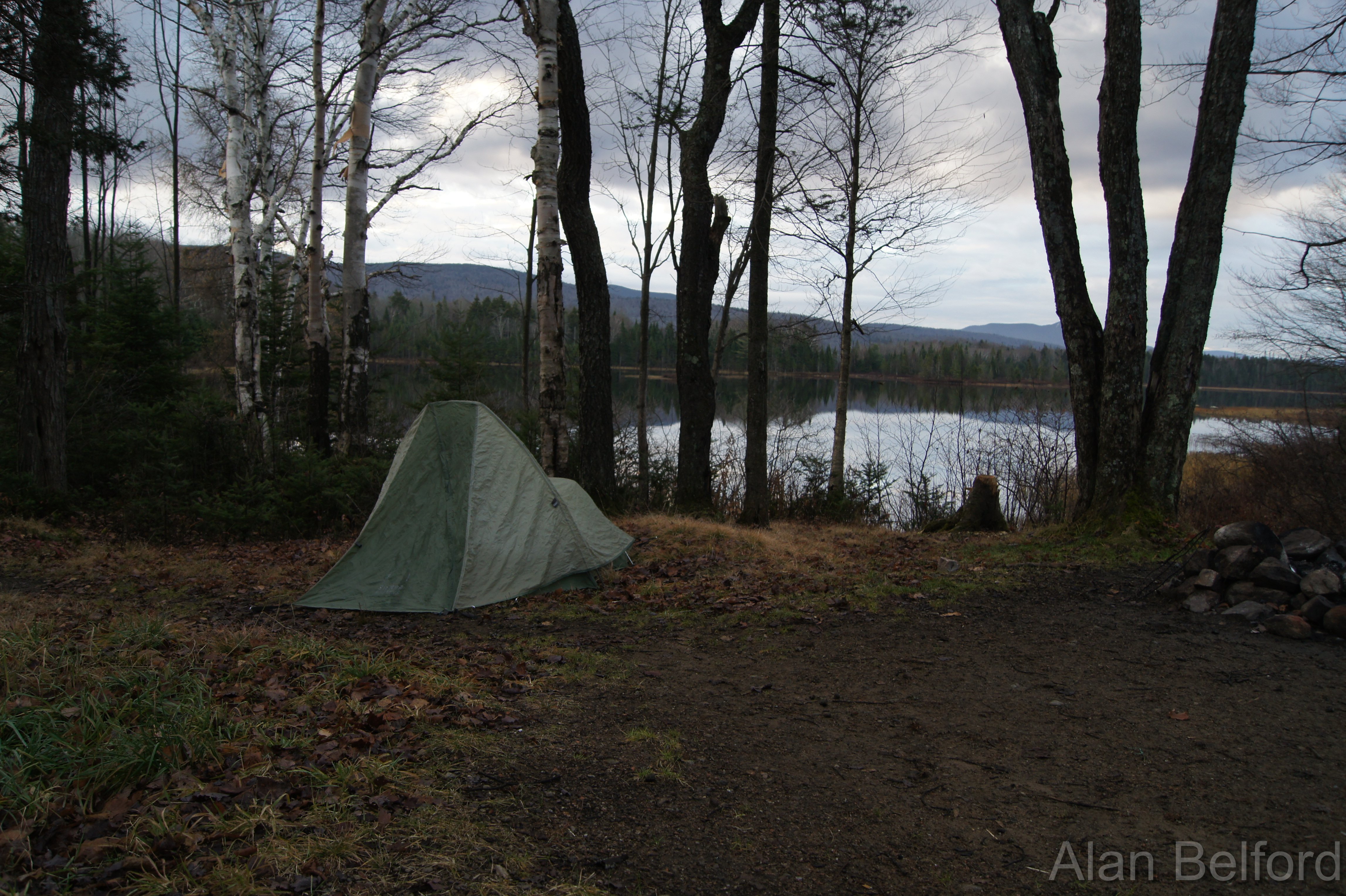 A tent set up by a waterside campsite 