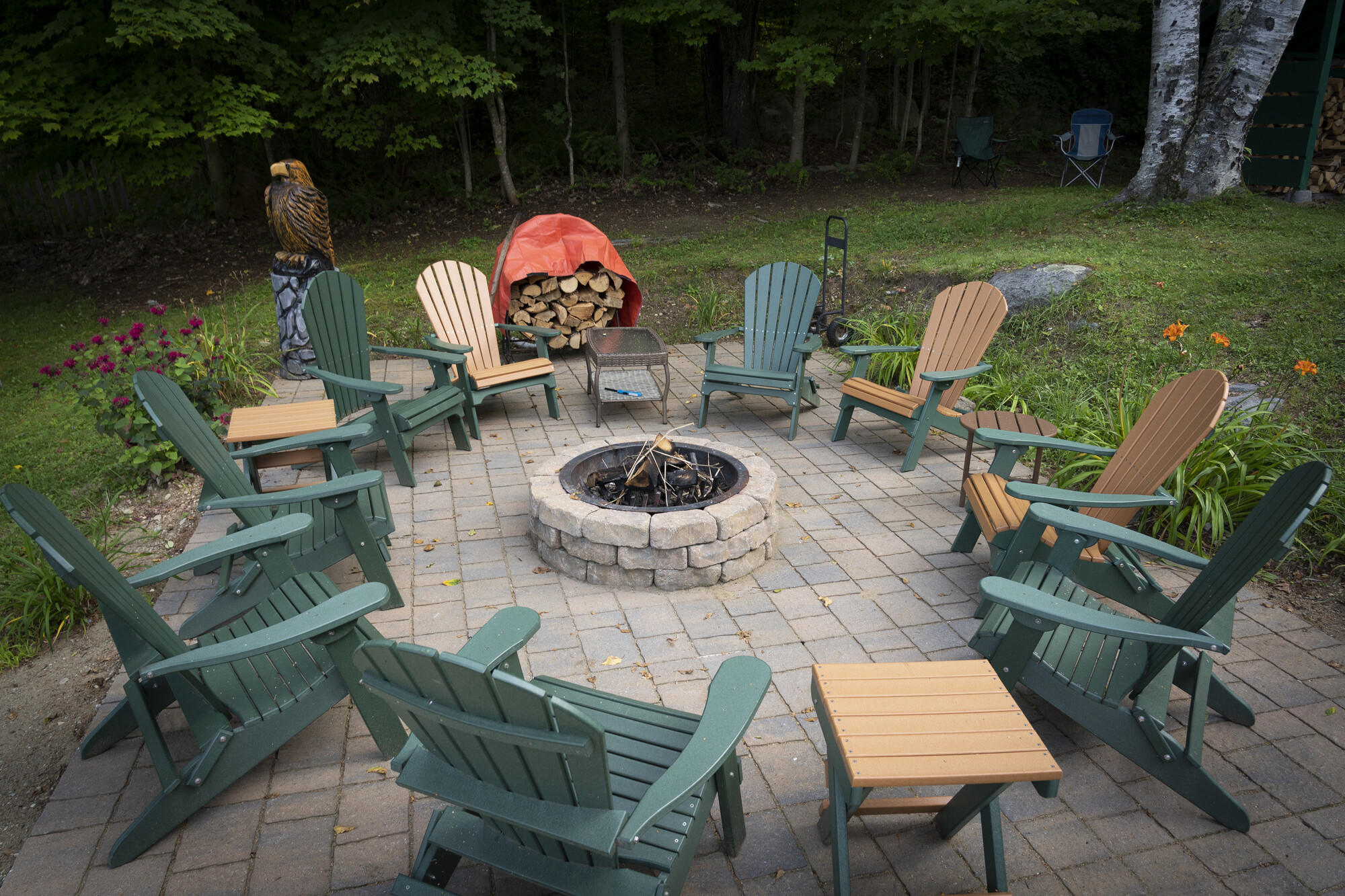 A stone patio with Adirondack chairs. 