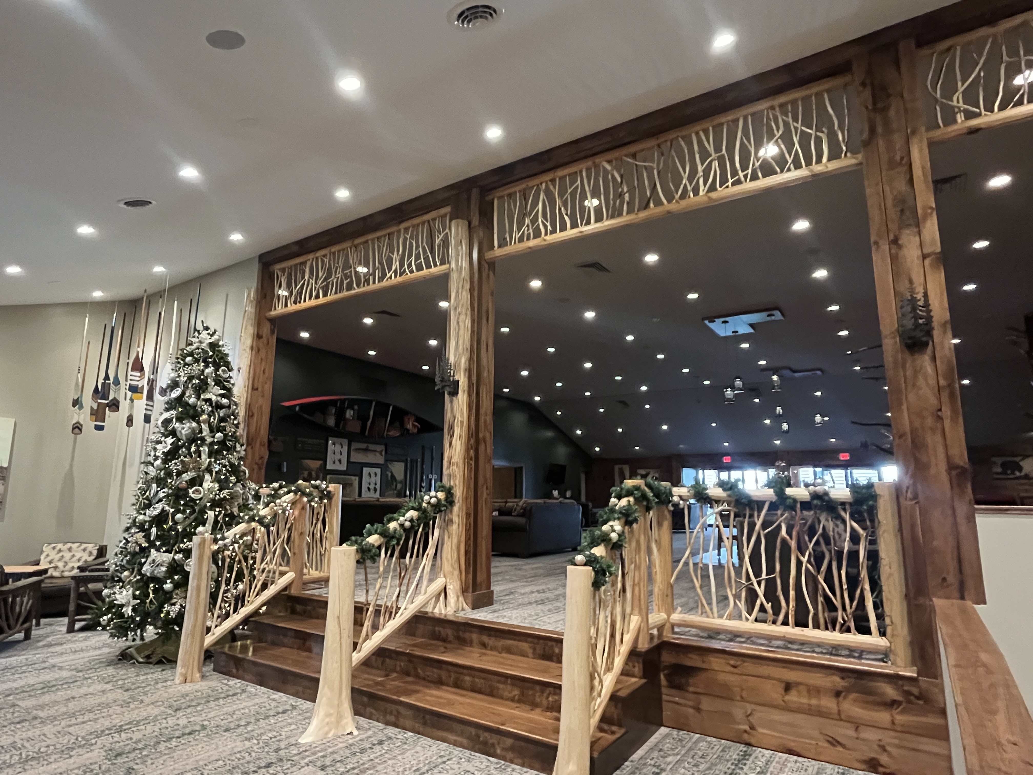 Decorative garland adorns the rustic bentwood railings along a small stairway inside The Lodge at Schroon Lake